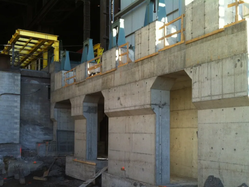 New concrete foundations and walls with steel components awaiting installation.