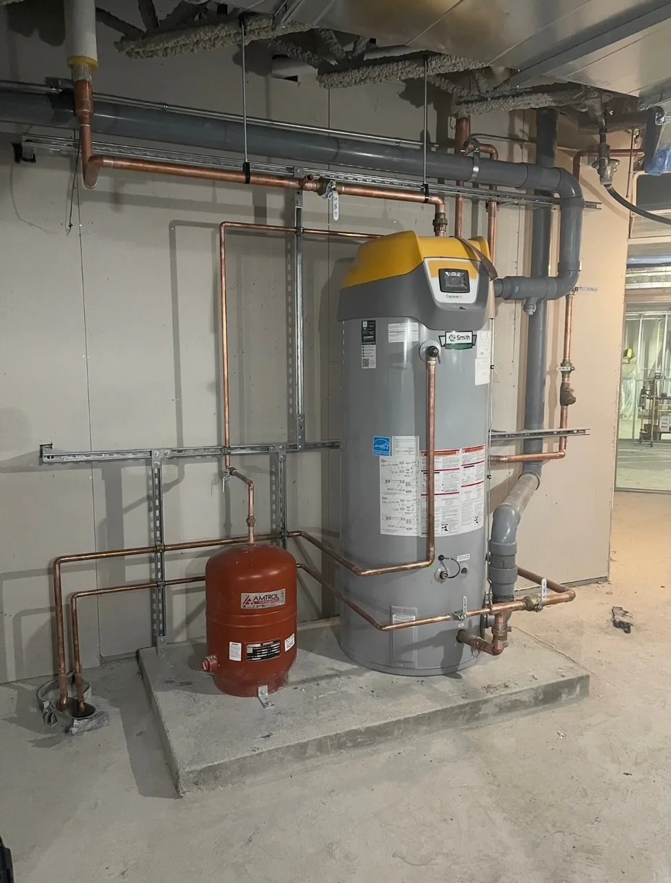 Commercial water-heating equipment with copper piping, expansion tank and wall-mounted components.