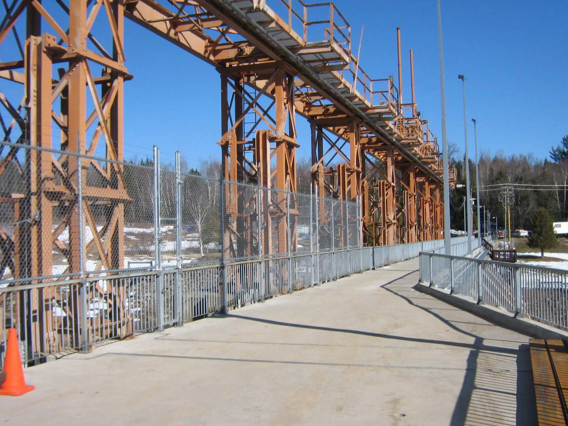 Completed industrial steel walkway or pipe-rack structure includes stairs, guardrails and elevated platforms.